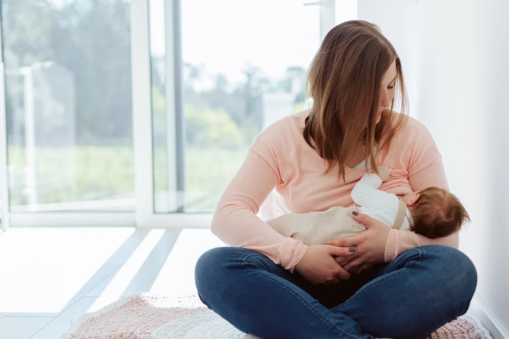mom sitting on floor breastfeeding baby