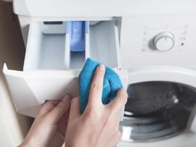 hands wiping soap and fabric softener tray
