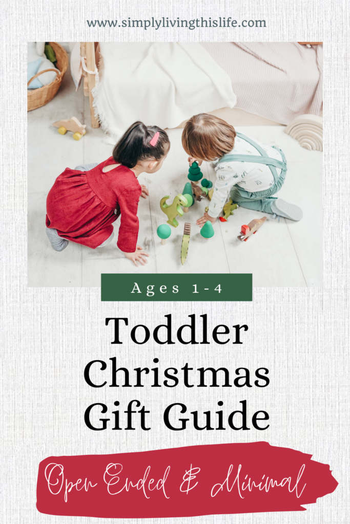 Two children playing on the white floor with wooden painted toys. With words below saying "Ages 1-4 Toddler Christmas Gift Guide, Open ended & minimal"