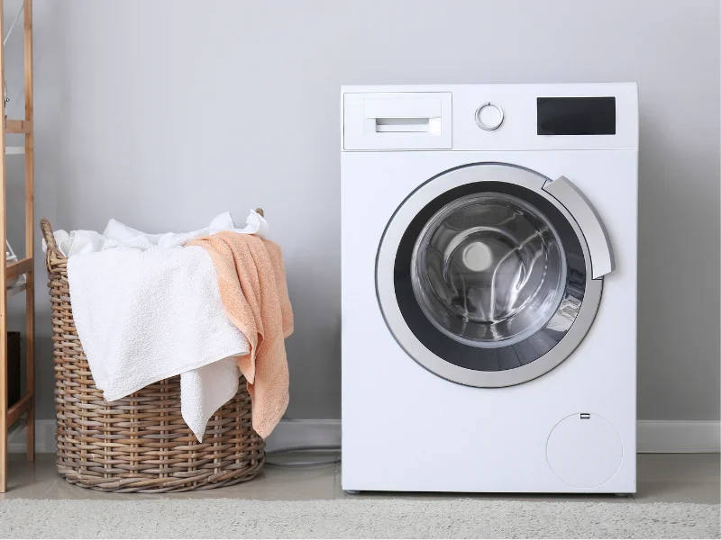 full laundry basket next to a washing machine