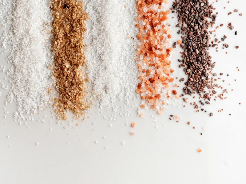 various types of salt lined up on a white table