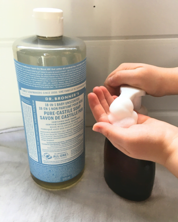 Dr. Bonner's Castile soap next to an amber foaming soap pump with a child's hands pumping soap.