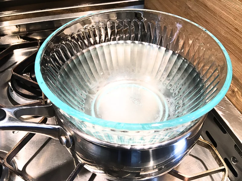 DIY double boiler with a glass bowl on top of a pot with some water in the bottom