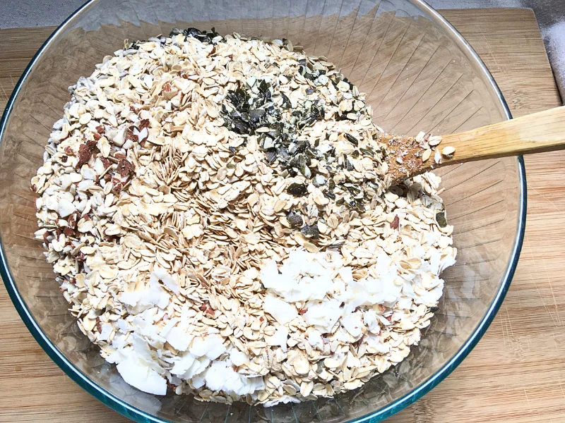 mixing granola ingredients in a glass bowl