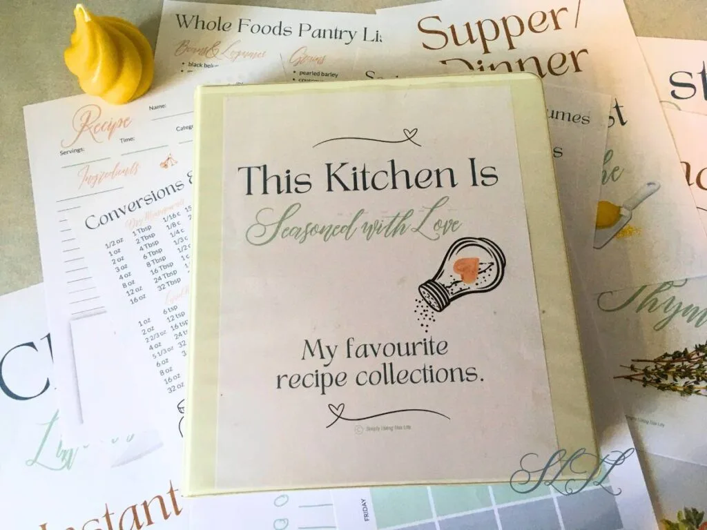 recipe binder on top of recipe binder organizer ebook printables with beeswax candle next the paper