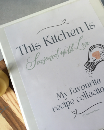 recipe binder on wooden cutting board with beeswax candle