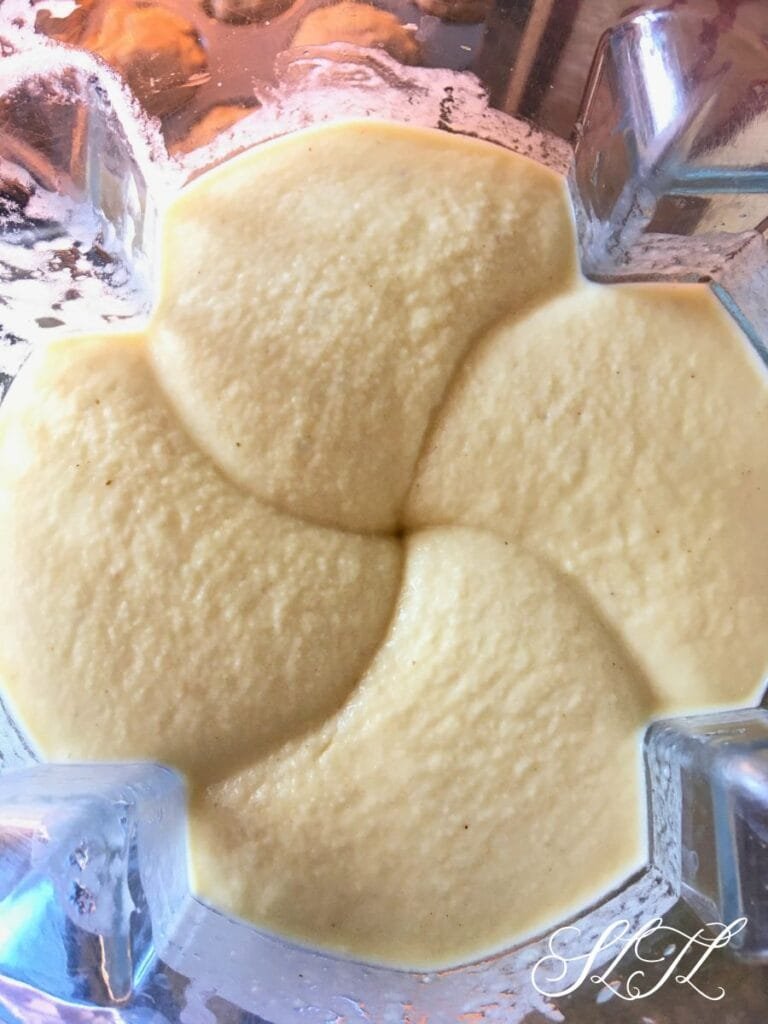 Top view of smoothly blended pinna colada smoothie in blender.
