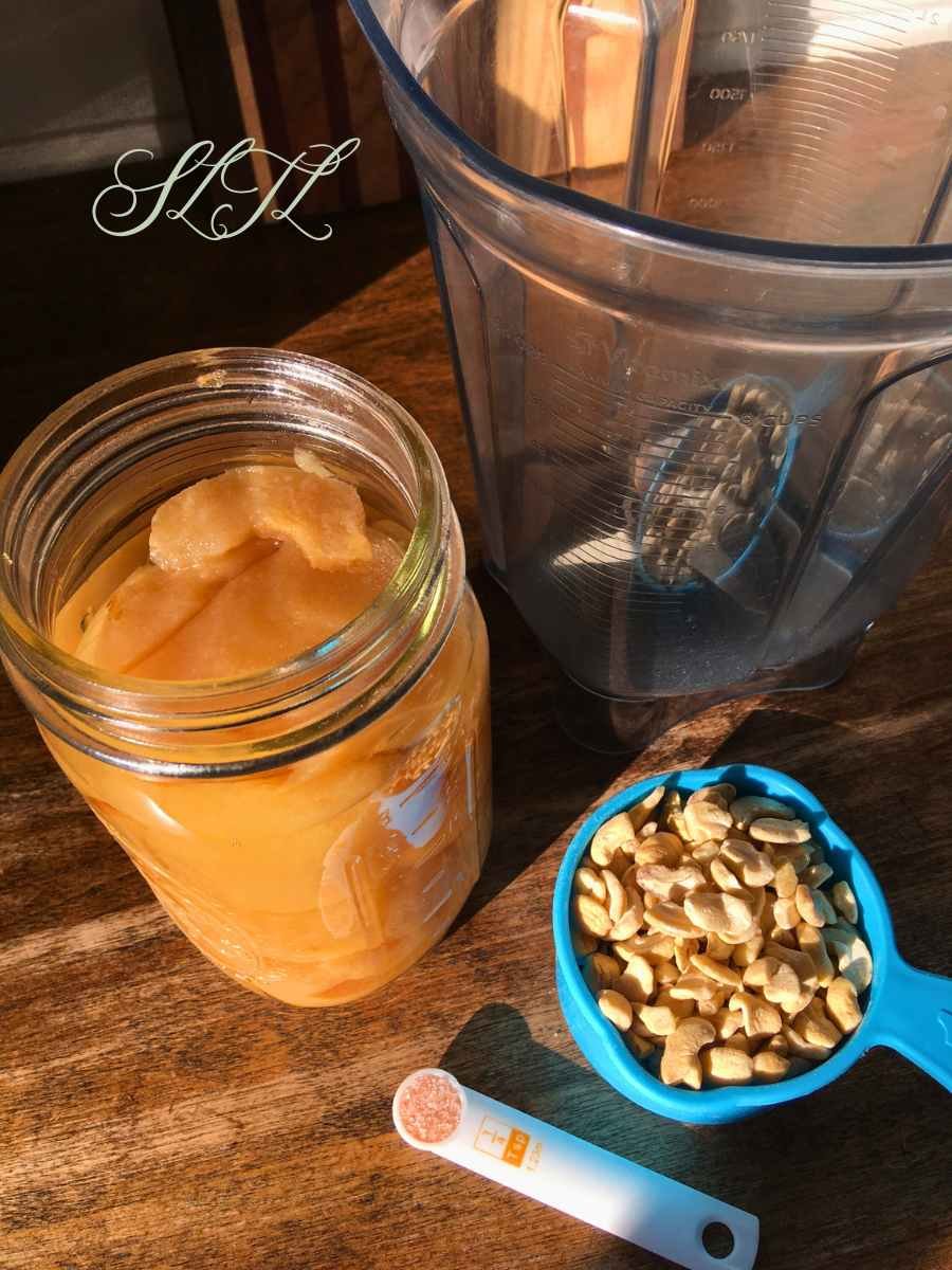 canned pears, cup of raw cashews, Himalayan salt, and blender sitting on a counter